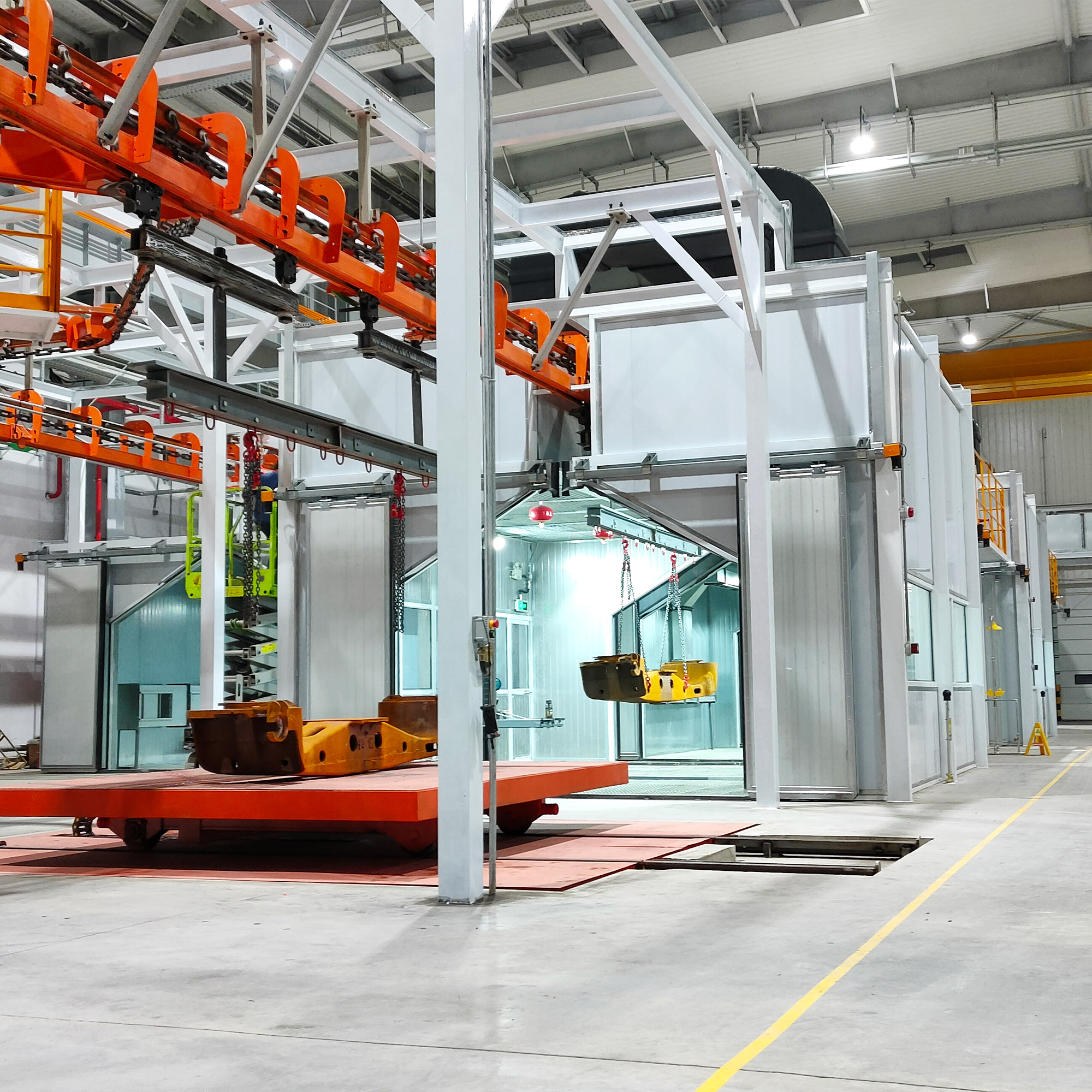 Overhead power-and-free conveyor chain with hooks carrying a component through a workshop